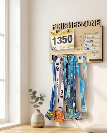Tableau des Records en bois gravé Finisherzone avec dossard, chronos personnels et médailles au-dessus d'un bureau